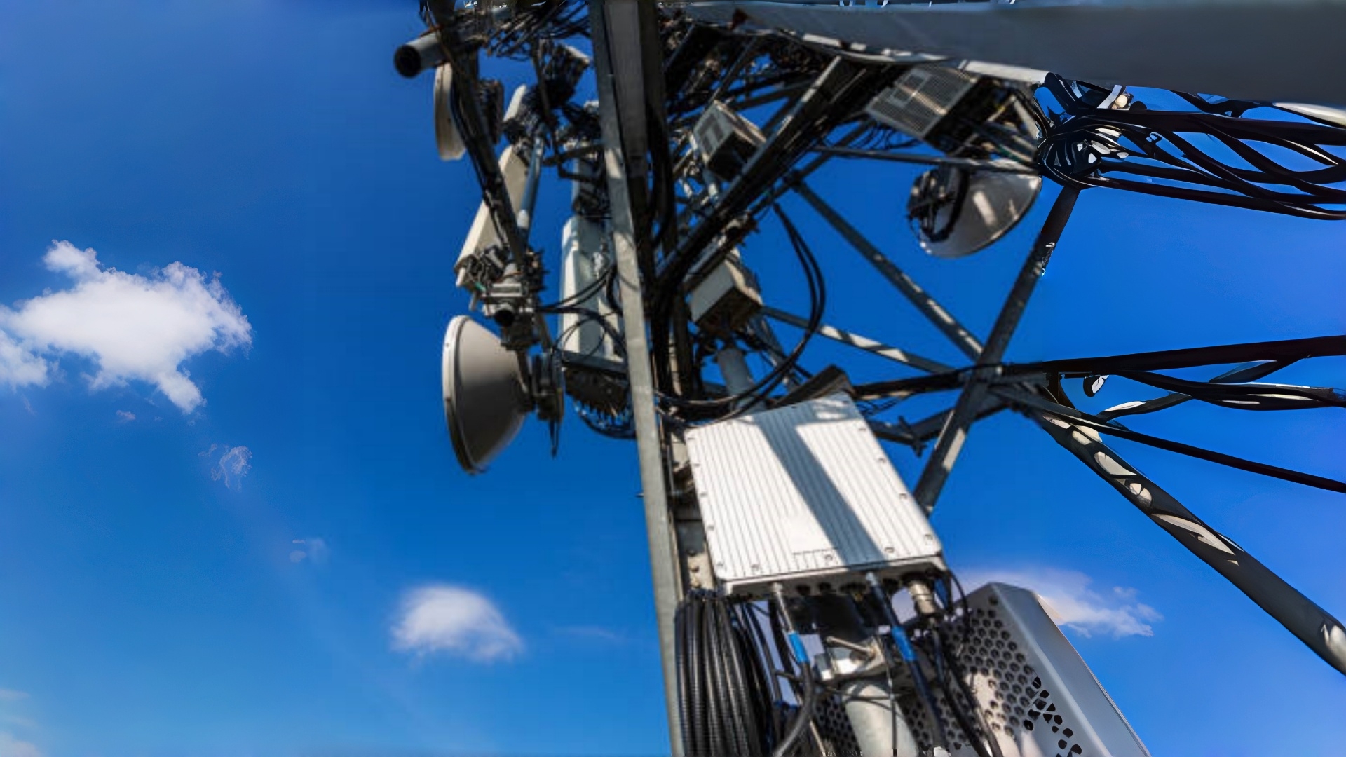 Telecommunication mast with microwave equipment, radio panel antennas, outdoor remote radio units, power cables, coaxial cables, optic fibers